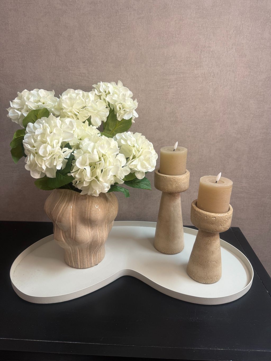 Decoratieset met witte hortensia’s in beige vaas en twee kandelaars met LED-kaarsen op wit dienblad, sfeervol voor tafel of kast.