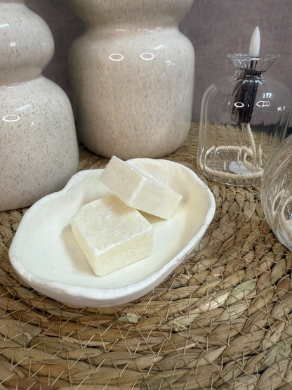 Tafel decoratie set Lovi – beige vazen met eucalyptus­takken, LED-oliekaarsjes en amberblokjes op gevlochten placemat.