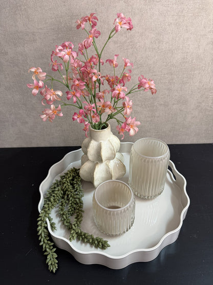 Tafel decoratie set Lulu met rond beige dienblad, vaas met roze bloemen, groene hangplant en twee glazen houders.
