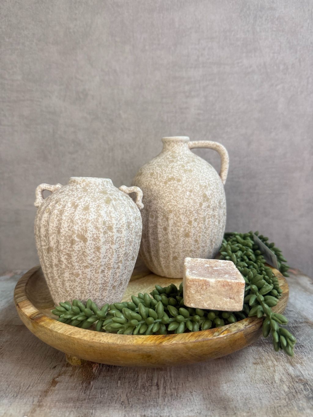 Tafel decoratie set Rome – beige vazen op houten dienblad met amberblokje en groene kunstplant tegen grijze achtergrond.