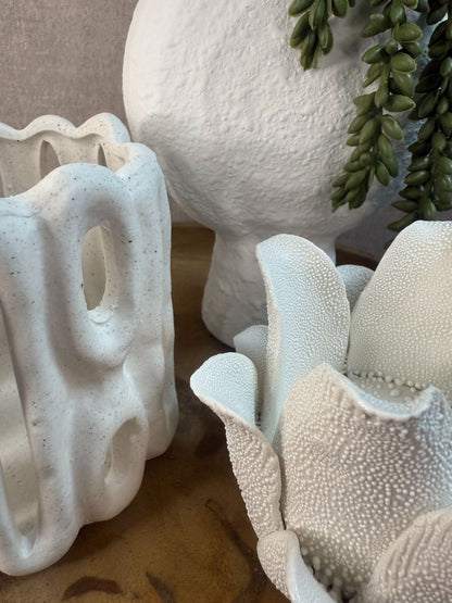 Tafel decoratie op houten schaal met wit keramiek: lotus theelichthouder, open waxinelichthouder en vaasje met hangende kunstplant.