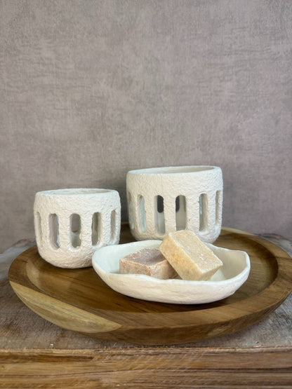 Rustieke tafeldecoratieset met houten dienblad, witte houders en amberblokjes op een houten ondergrond.