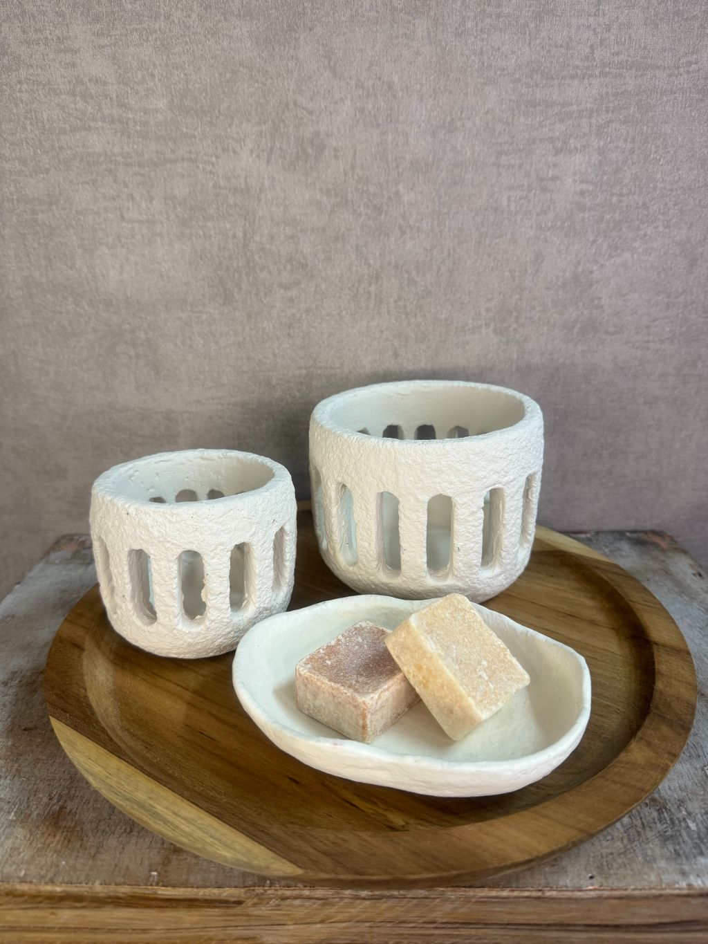 Rustieke tafeldecoratieset met houten dienblad, witte houders en amberblokjes op een houten ondergrond.