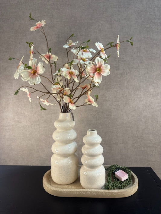 Tafeldecoratieset met beige vazen, bloeiende roze-witte takken, amberblokje en kunstplantje op marmerlook dienblad.