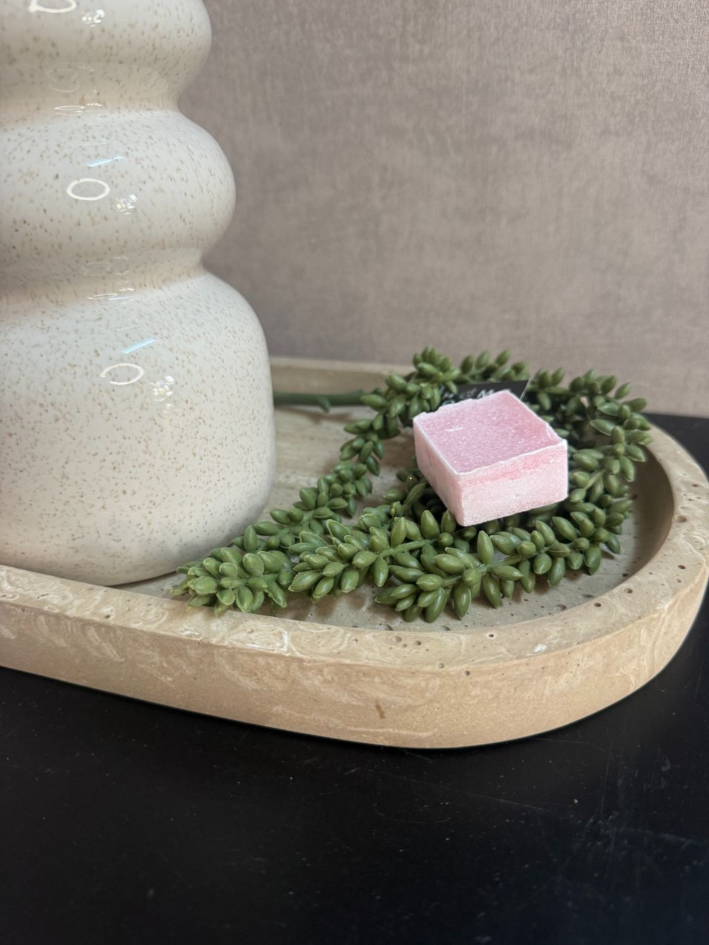 Tafeldecoratieset met beige vazen, bloeiende roze-witte takken, amberblokje en kunstplantje op marmerlook dienblad.