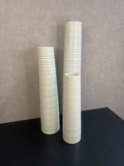 Vaas Gwinn crème – drie keramieken vazen met subtiele strepen in verschillende hoogtes tegen een grijze achtergrond.