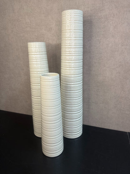 Vaas Gwinn crème – drie keramieken vazen met subtiele strepen in verschillende hoogtes tegen een grijze achtergrond.
