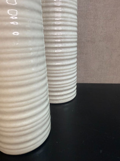 Vaas Gwinn crème – drie keramieken vazen met subtiele strepen in verschillende hoogtes tegen een grijze achtergrond.