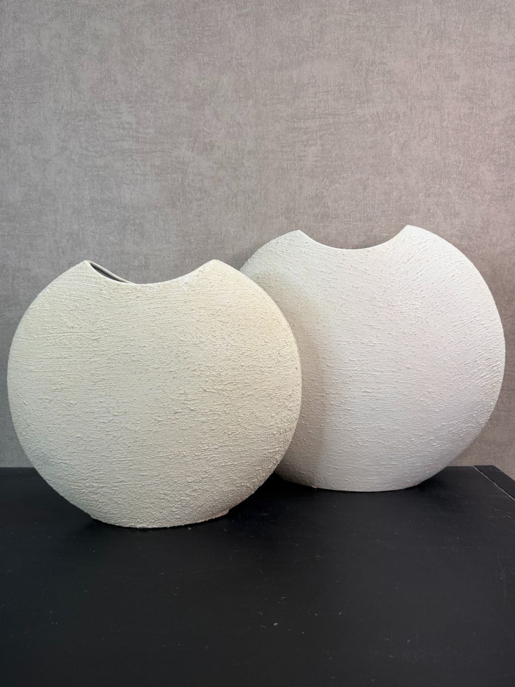 Crèmekleurige metalen vaas Ibbo met organische ronde vorm, getoond in twee formaten met subtiele tintverschillen.