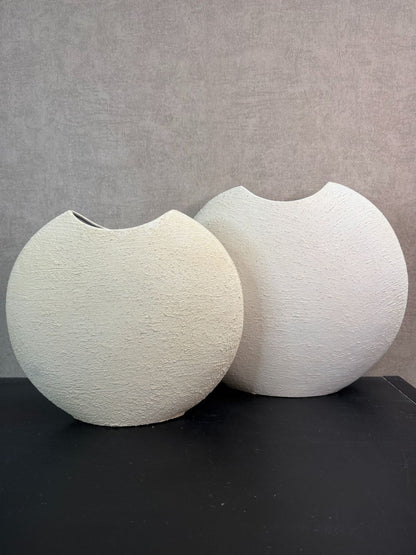 Crèmekleurige metalen vaas Ibbo met organische ronde vorm, getoond in twee formaten met subtiele tintverschillen.