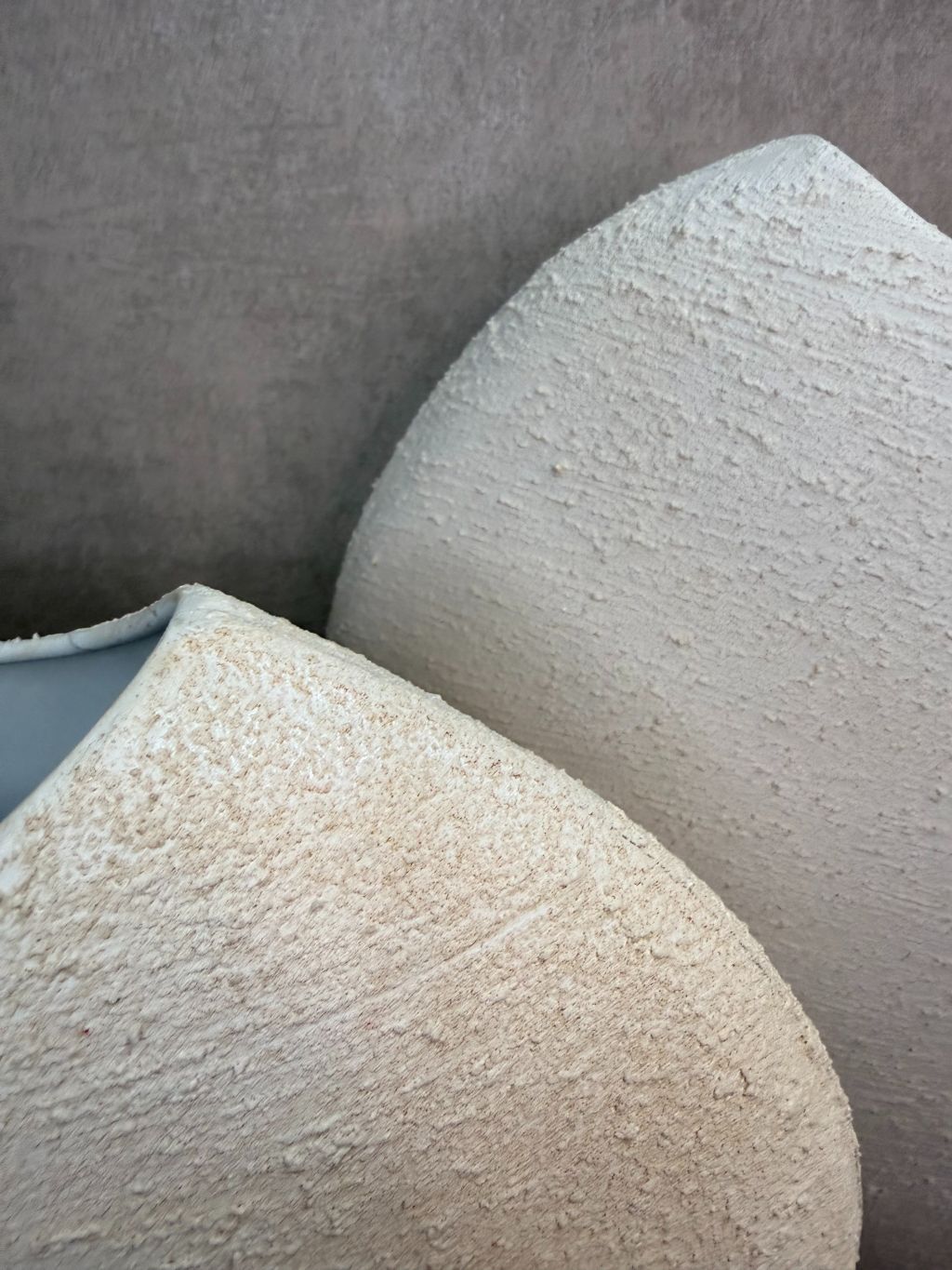 Crèmekleurige metalen vaas Ibbo met organische ronde vorm, getoond in twee formaten met subtiele tintverschillen.