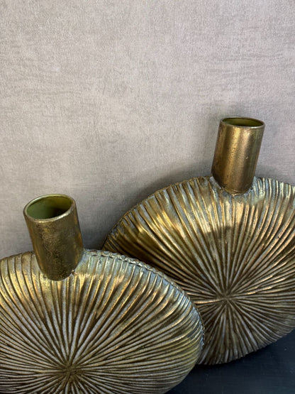 Goudkleurige metalen vaas Libera met rond, plat design en reliëfstructuur, getoond in twee formaten op een donkere ondergrond.