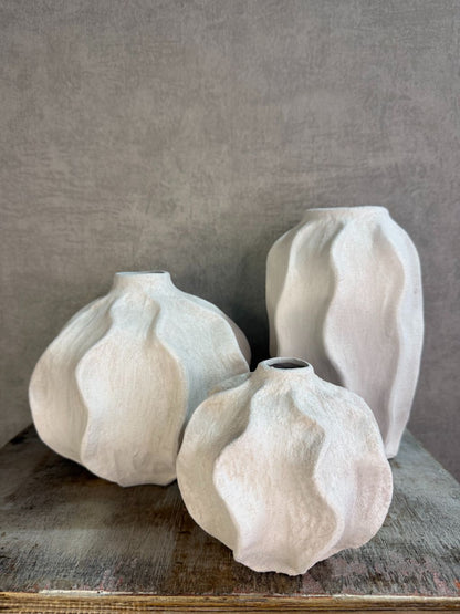 Handgemaakte witte keramieken vaas Lisboa in drie formaten met organische vorm, stijlvol opgesteld op een houten ondergrond.