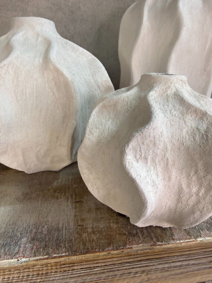 Handgemaakte witte keramieken vaas Lisboa in drie formaten met organische vorm, stijlvol opgesteld op een houten ondergrond.