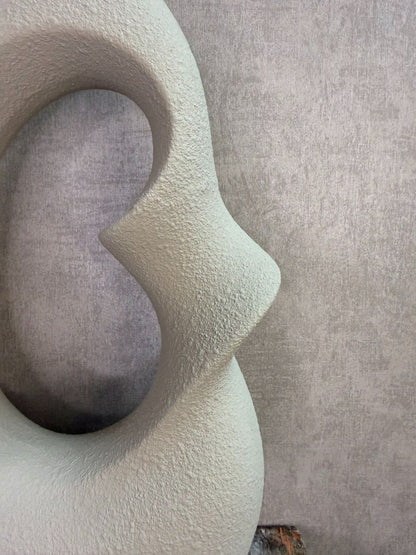 Set van twee beige keramieken vazen met organische open vorm in verschillende formaten op een houten ondergrond.