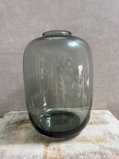 Grote glazen vaas Toronto in transparant grijs met ronde vorm, geplaatst op een houten ondergrond.