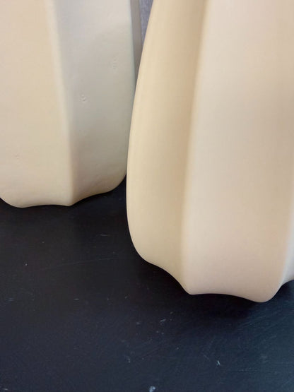 Bruine glazen vaas met facetvormig design in drie verschillende hoogtes, geplaatst op een donkere ondergrond.