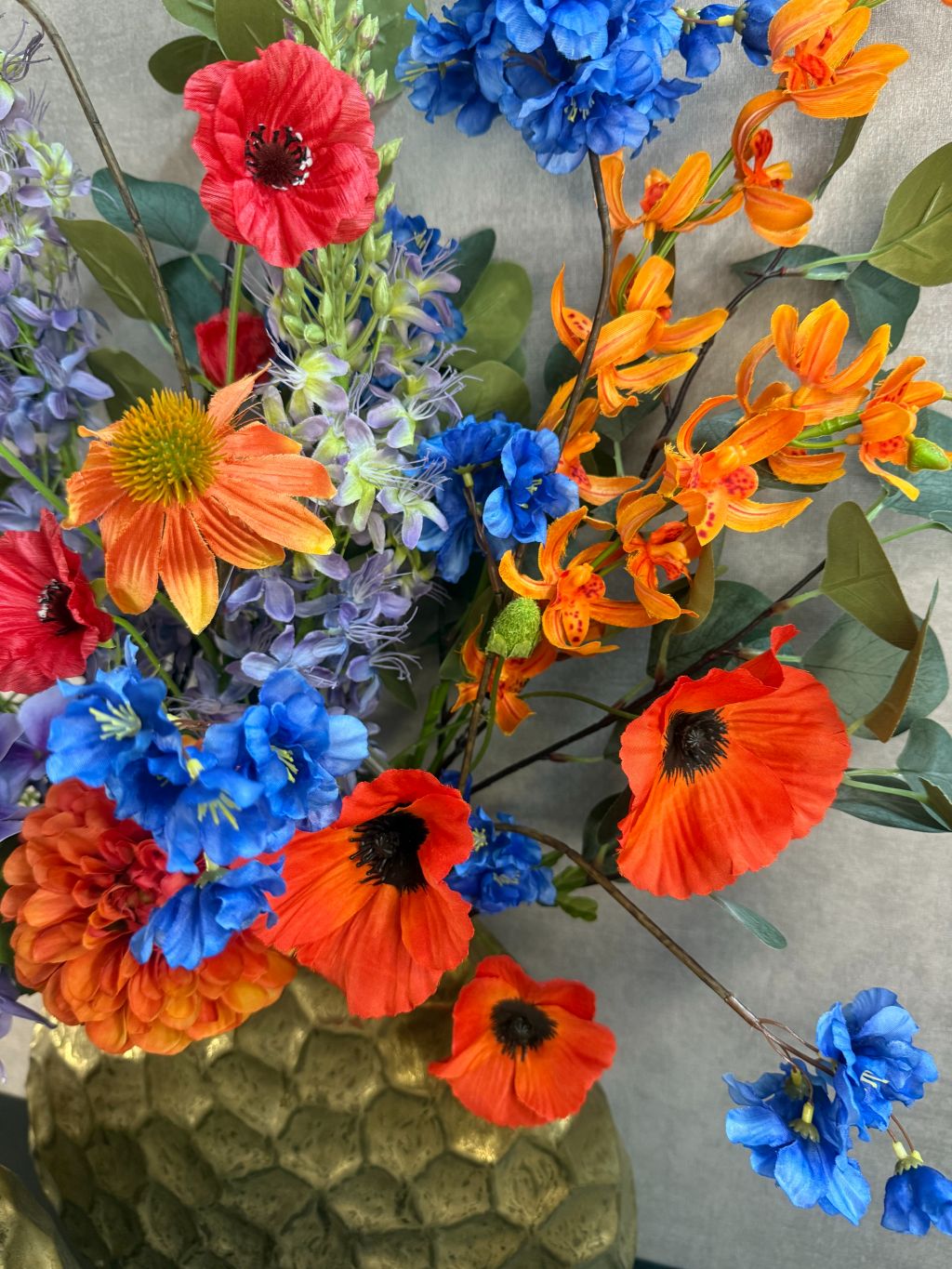kleurrijk boeket van 13 stelen in oranje, paars, blauw, rood en groen.