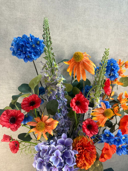 kleurrijk boeket van 13 stelen in oranje, paars, blauw, rood en groen.