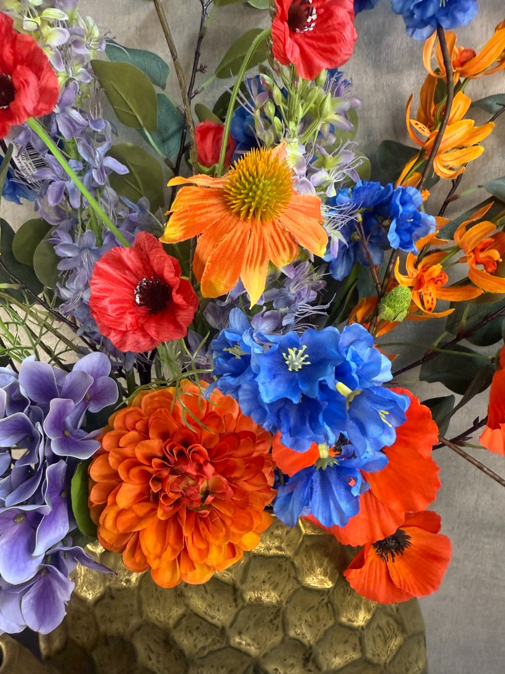 kleurrijk boeket van 13 stelen in oranje, paars, blauw, rood en groen.