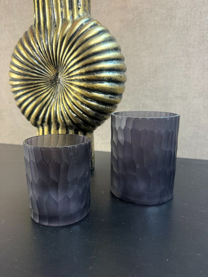 gouden ribbelvaas en twee zwarte waxinelichthouders.
