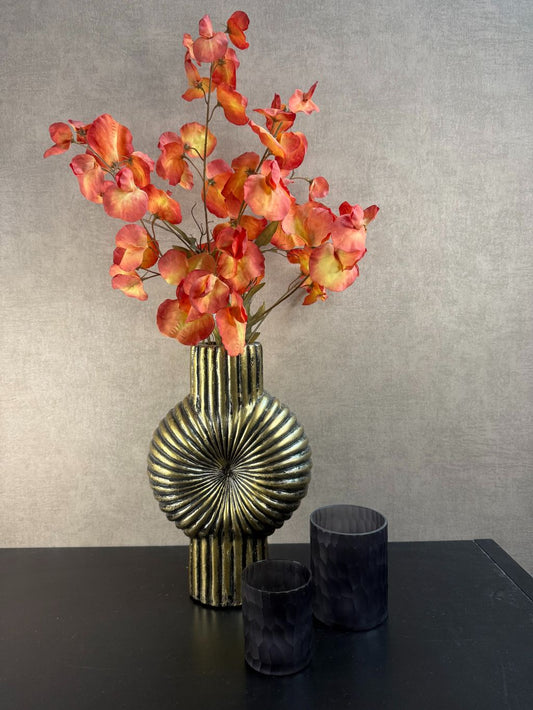 Vensterbank decoratie set Dexx met gouden ribbelvaas, oranje kunsttakken en twee zwarte waxinelichthouders.