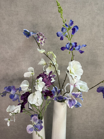 Vensterbank decoratie set Gwen met twee witte keramieken vazen en bloemen in wit, paars en blauw.