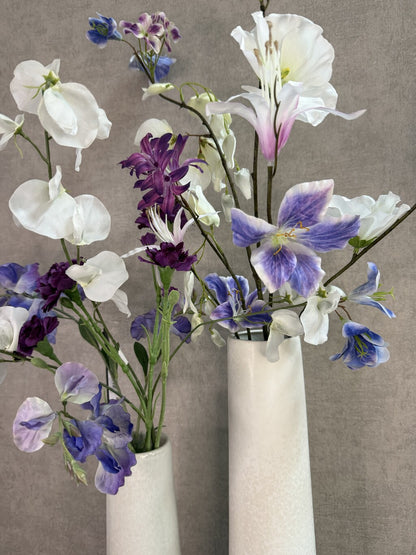 Vensterbank decoratie set Gwen met twee witte keramieken vazen en bloemen in wit, paars en blauw.