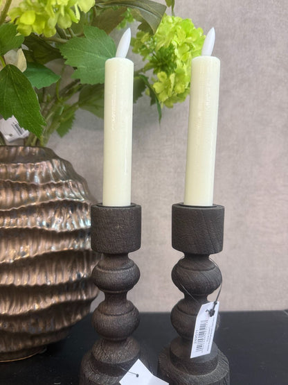 Vensterbank decoratie set Meave – bronzen vaas met groene en crème bloemen, houten kandelaars met LED-kaarsen op zwarte ondergrond.