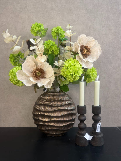 Vensterbank decoratie set Meave – bronzen vaas met groene en crème bloemen, houten kandelaars met LED-kaarsen op zwarte ondergrond.