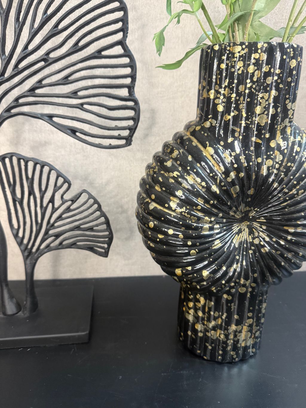 Vensterbank decoratieset met zwarte vaas met goudspikkels, oudroze kunstbloemen en zwart metalen ginkgo-ornament.