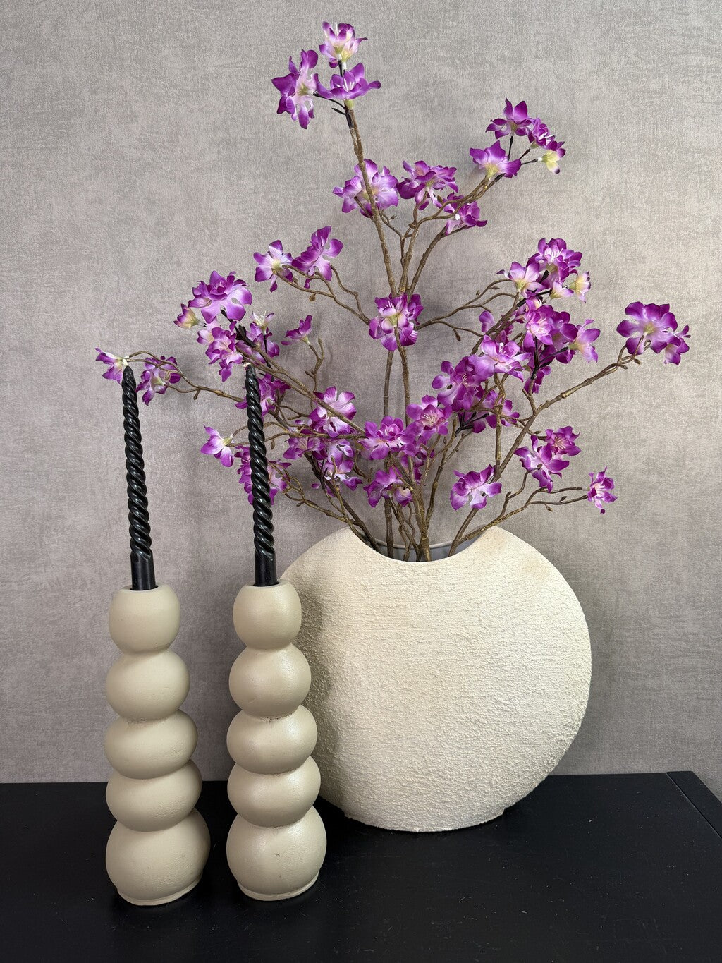 Vensterbank decoratie set Twist met crème vaas, paarse bloemen, kandelaren en zwarte twistkaarsen.