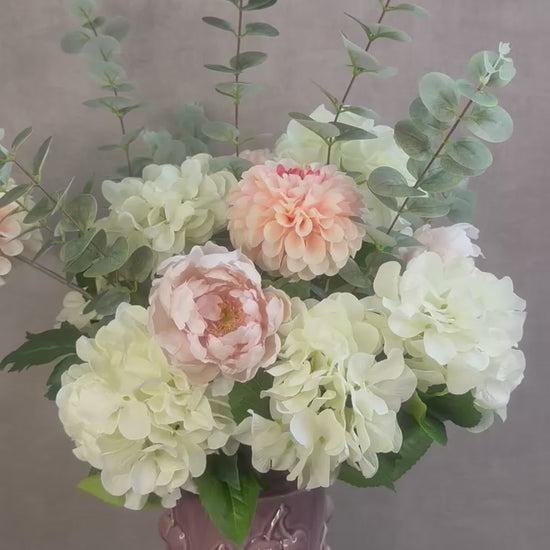 Video van Kunstboeket Amélie – zachte bloemen in ecru, roze en zalmtinten met eucalyptus, in roze vaas met kersenmotief.