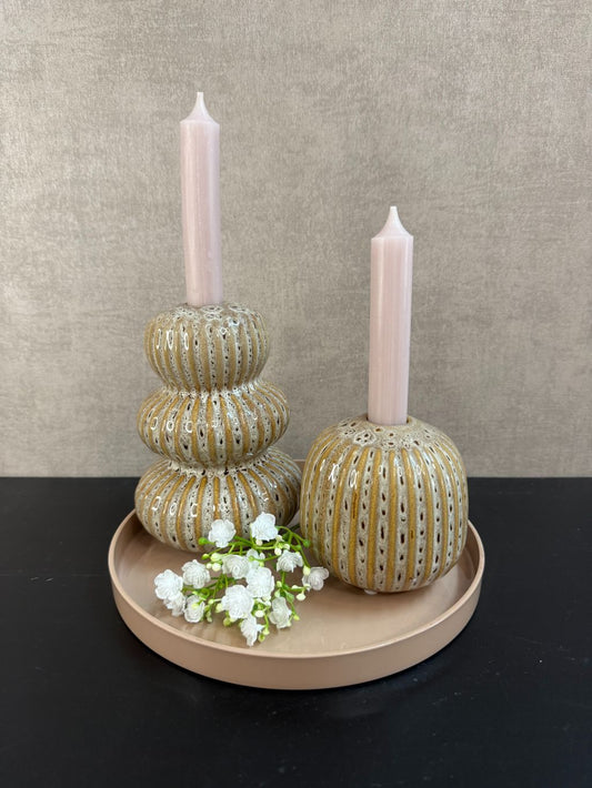 Tafeldecoratieset met zandkleurig dienblad, twee Aztec-kandelaren, nude kaarsen en wit gipskruidtakje tegen een rustige achtergrond.